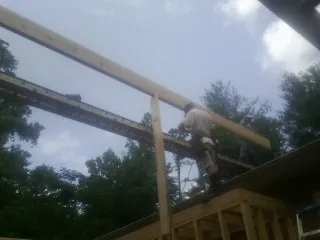 Carpenter setting a ridge beam over a new addition frame — Ice Dam Removal by Roofing Brothers in Grahamsville