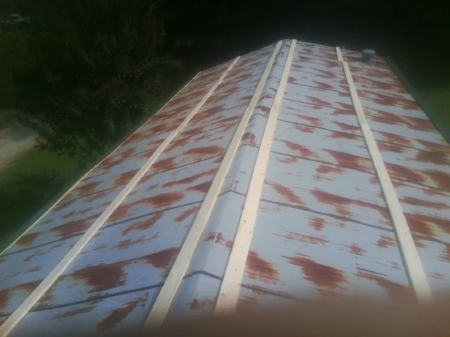 Rusted metal roof panels with new wood purlins before replacement — Storm Damage Roof Repair in Grahamsville by Roofing Brothers