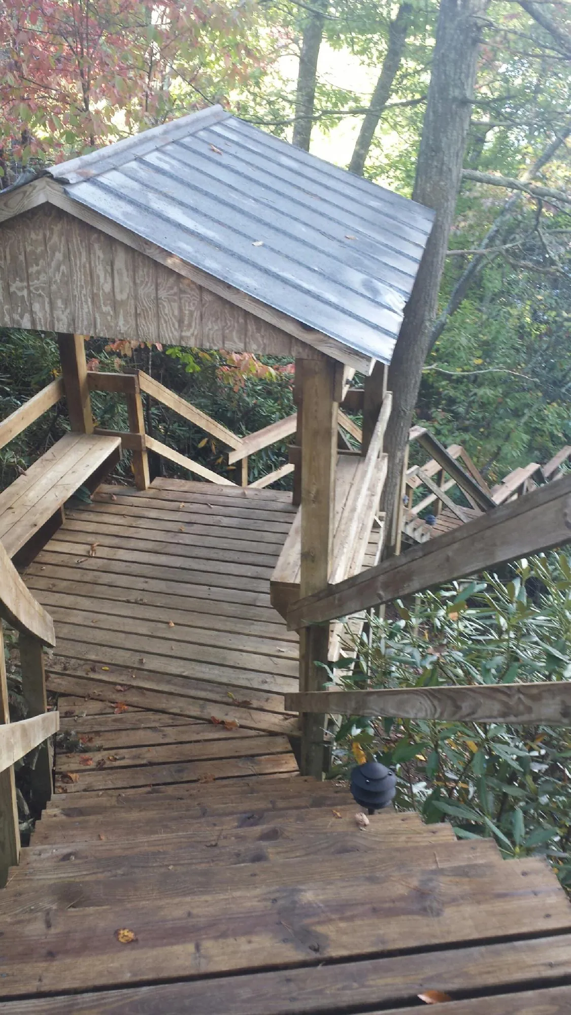 Metal roofed shelter over wooden steps on a wooded walkway — Skylight Repair & Installation work by our crew in Grahamsville