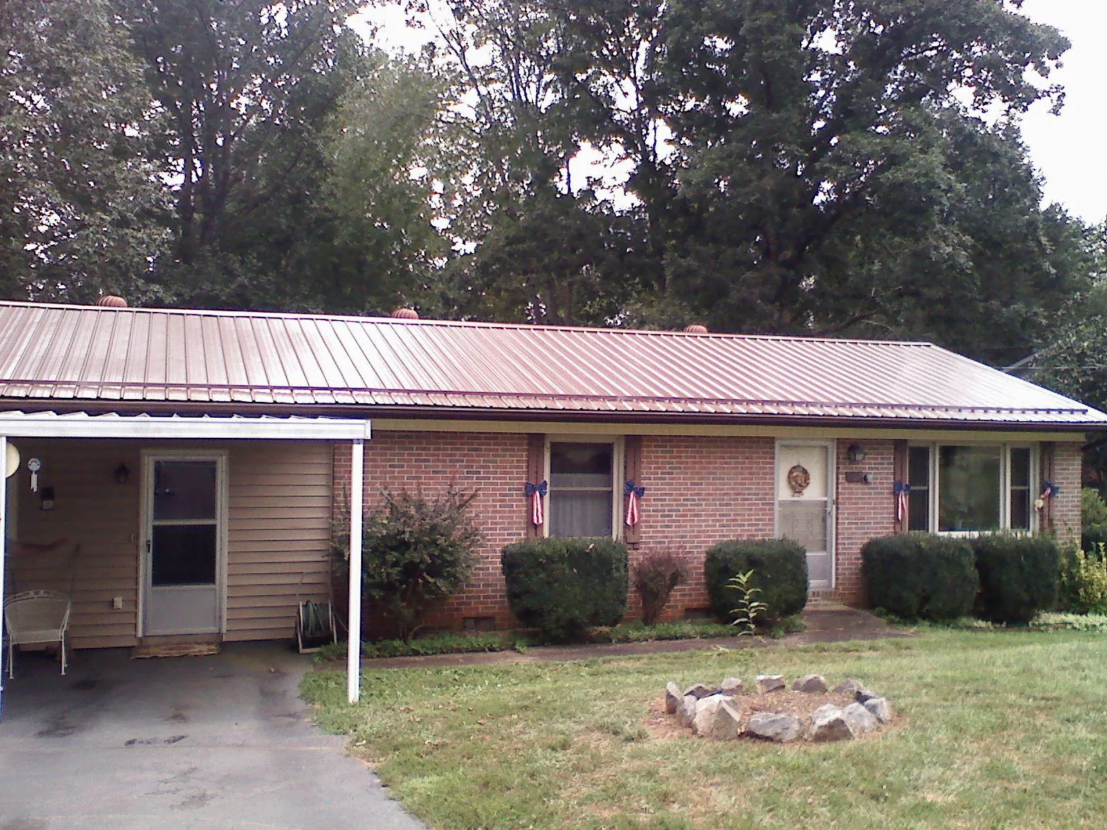 Bronze metal roof and carport on a brick ranch home — Roof Repair work by our crew in Grahamsville